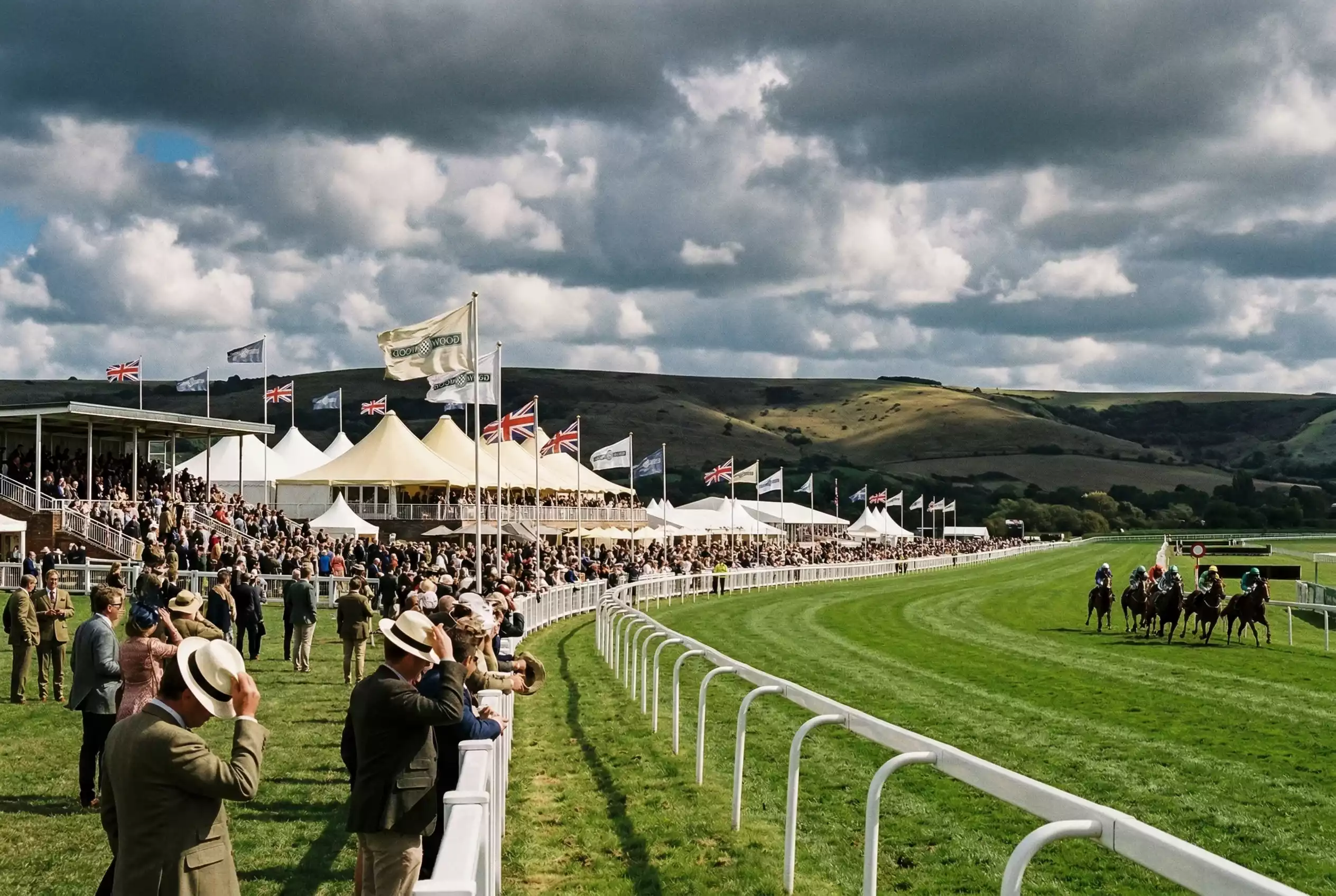 Wind blowing through the flags and marquees at Goodwood racecourse with dark clouds rolling over the Sussex Downs