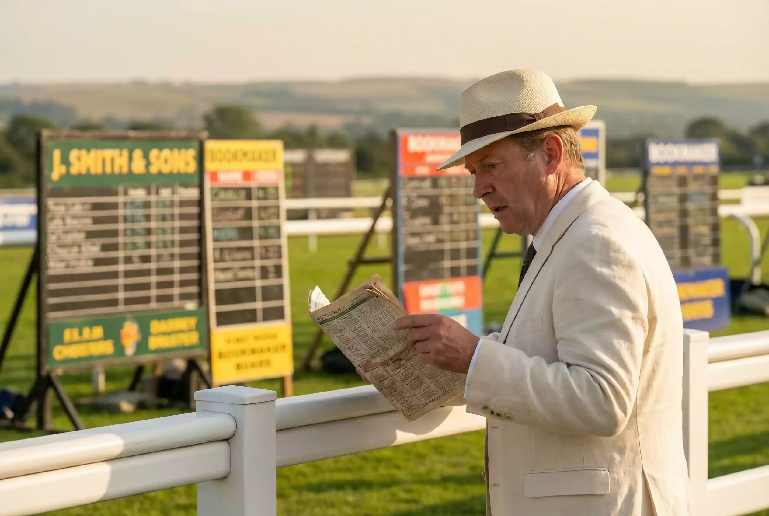 Racegoer studying a racecard at the Goodwood racecourse betting ring